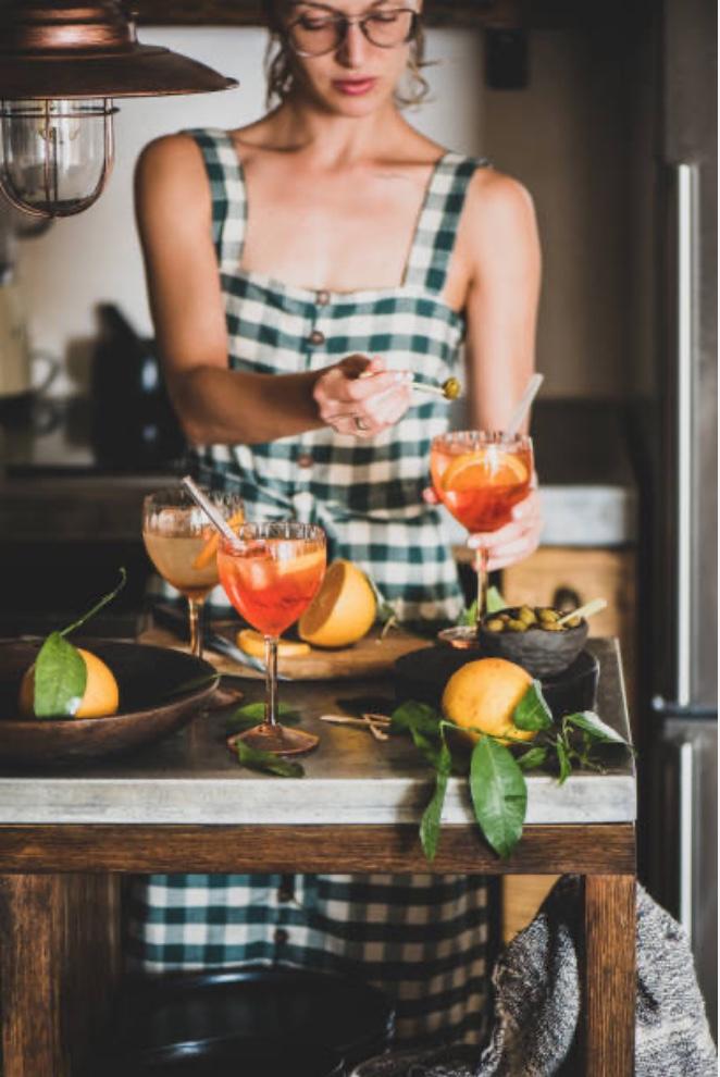 an attractive woman makes cocktails in the kitchen