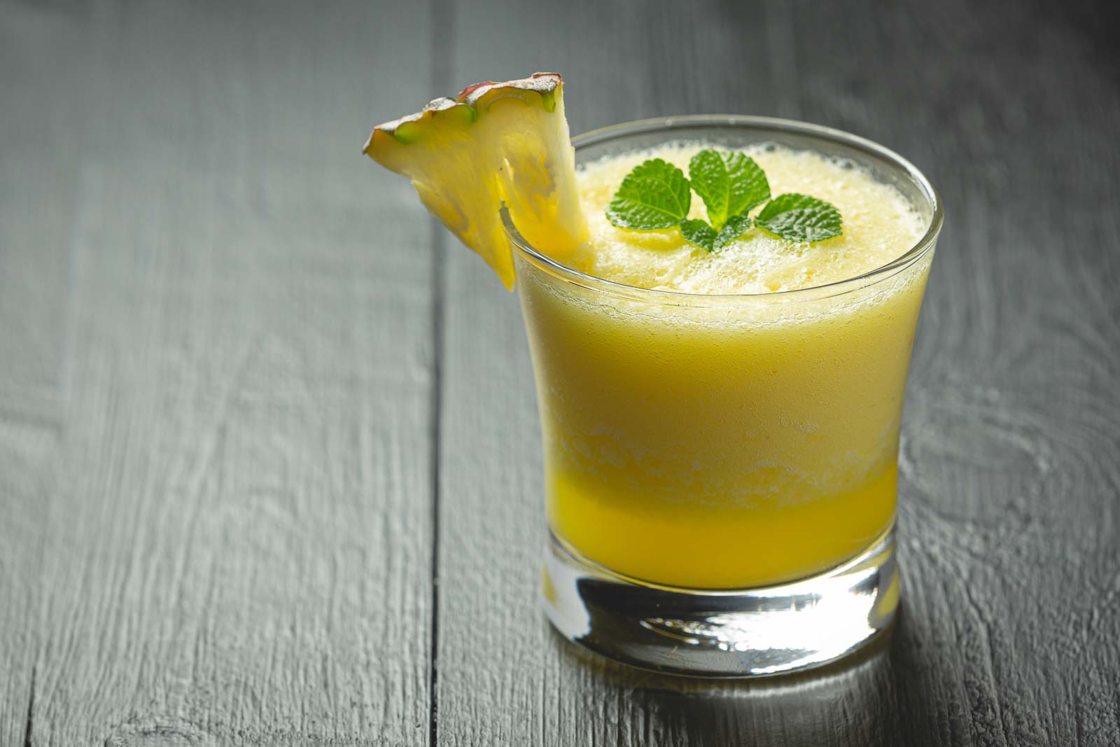 a small cocktail with a wedge of pineapple