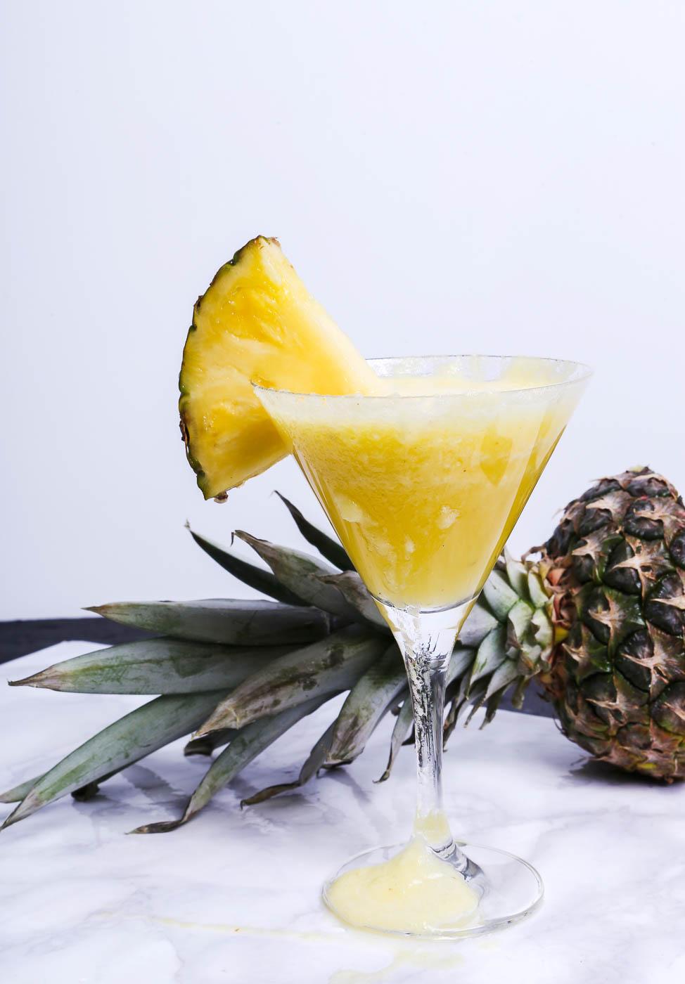a pineapple cocktail in a martini glass