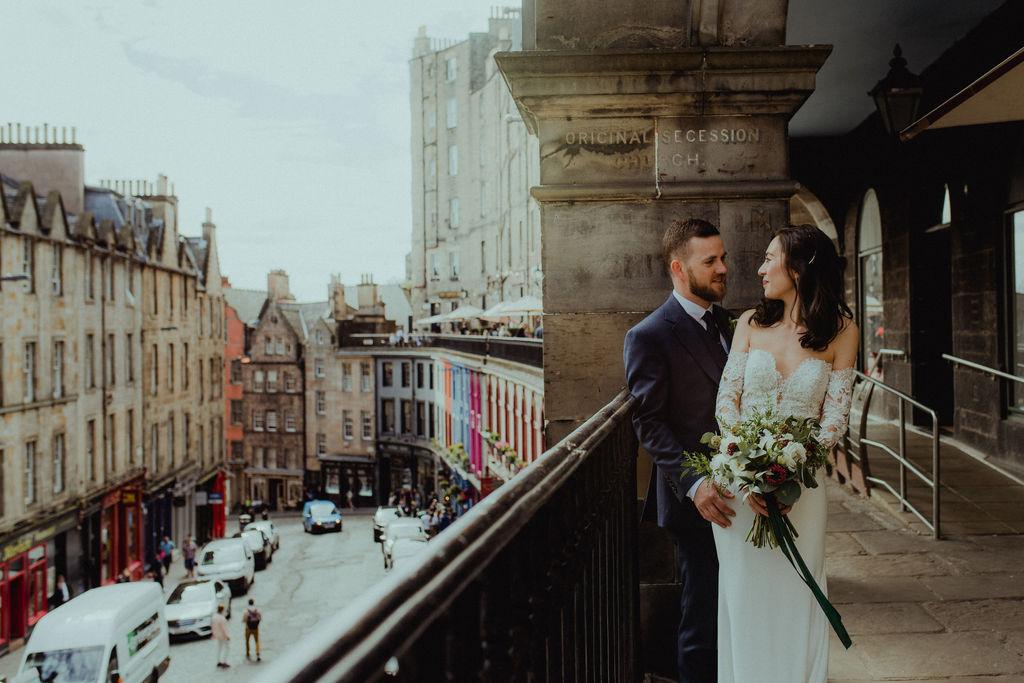 A newly wed couple on a balcony overlooking the royal mile in Edinburgh.